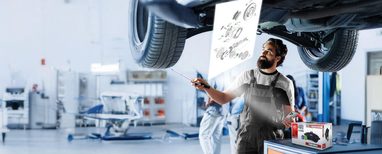Ferodo technical drawings Installer in a garage using a smartphone under bright lighting after scanning a Ferodo QR code to access technical drawings for brake parts